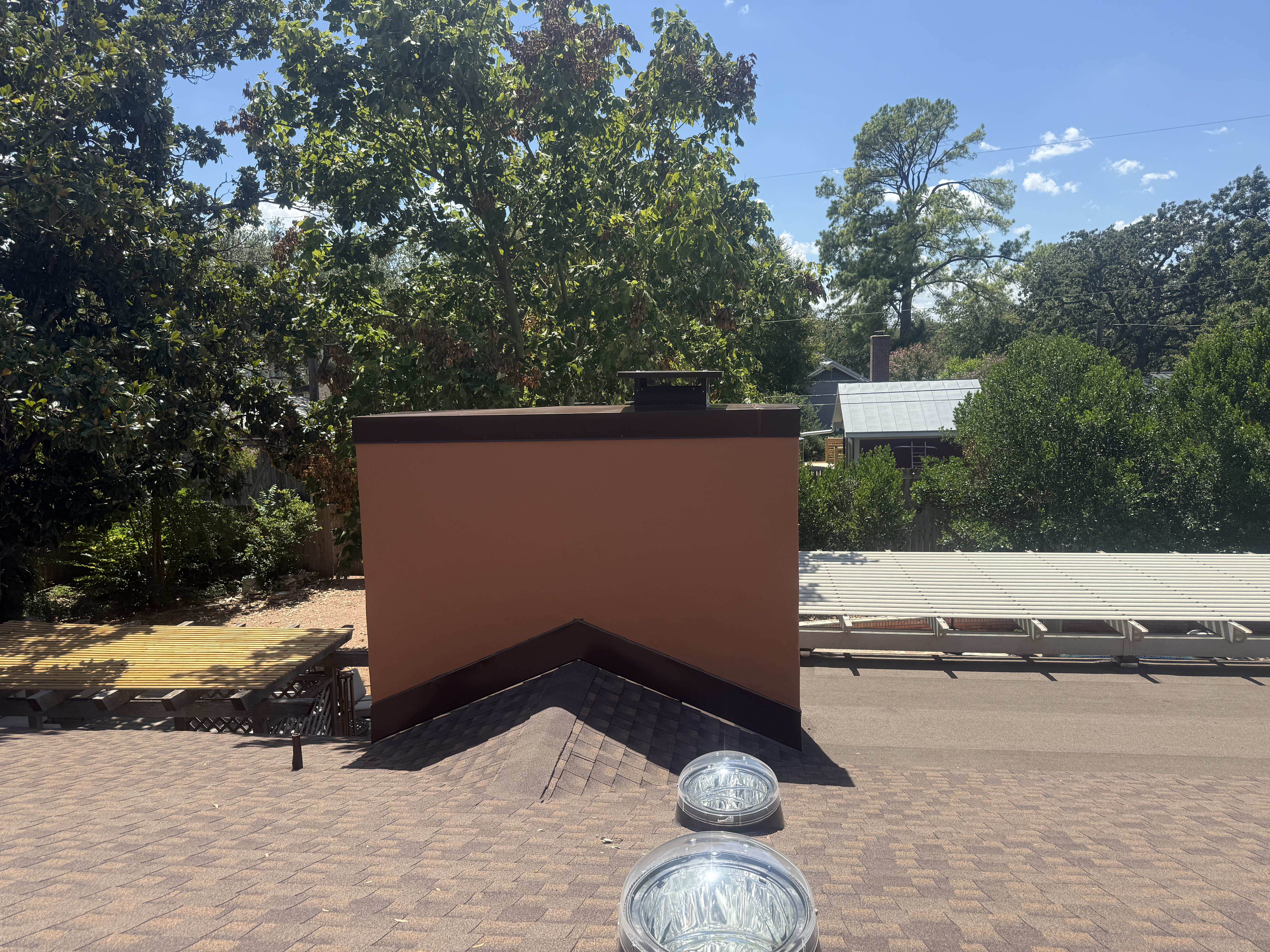 Oversized stucco chimney with dark cap